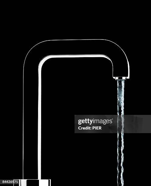 water pouring from faucet - waterkraan stockfoto's en -beelden