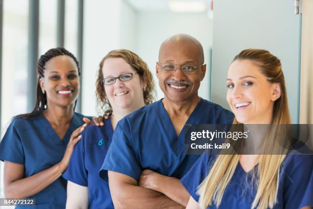 man leading team of multi-ethnic medical professionals - enfermagem imagens e fotografias de stock