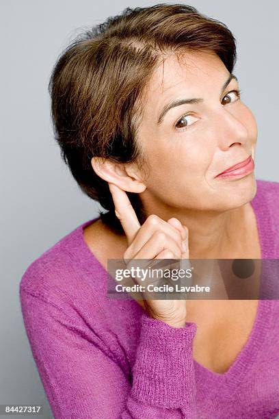 woman with finger behind ear - woman fingers in ears stock pictures, royalty-free photos & images