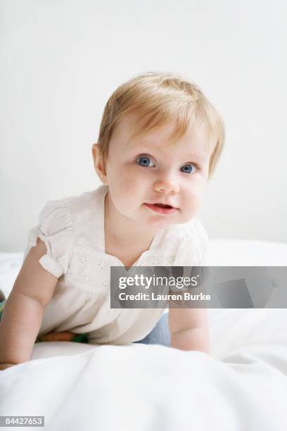 baby girl crawling on white bedding - one baby girl only bildbanksfoton och bilder