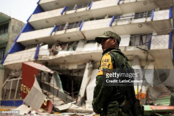 Member of Mexican Army stands in front of a ruined building after a 8.0-magnitude earthquake hit Mexico through the southern coast of Oaxaca on...