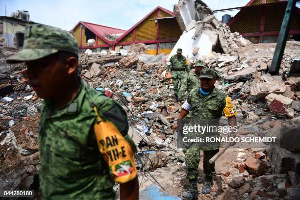 Mexican soldiers walk amid debris of the Town Hall building which partially collapsed following an 8.2 magnitude earthquake that hit Mexico's Pacific...