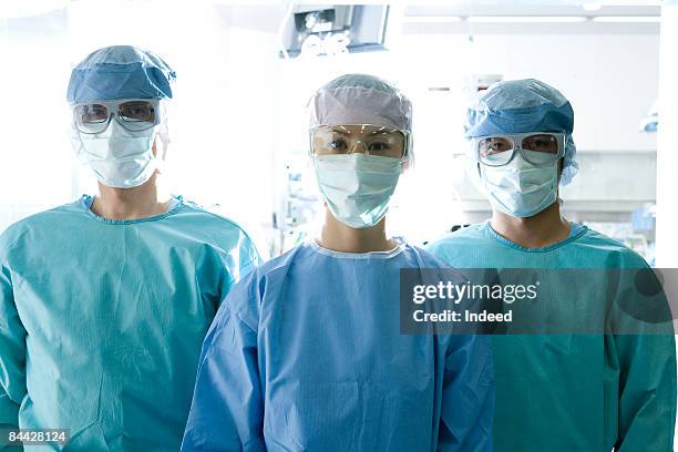 surgeons wearing surgical mask and eyewear - operating gown stock pictures, royalty-free photos & images