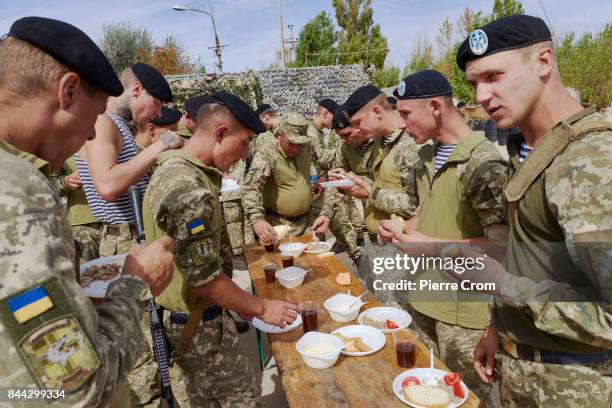 Ukrainian soldiers eat a lunch as inhabitants of Melekyne and Ukrainian servicemen commemorate the liberation of Mariupol from the German nazi...