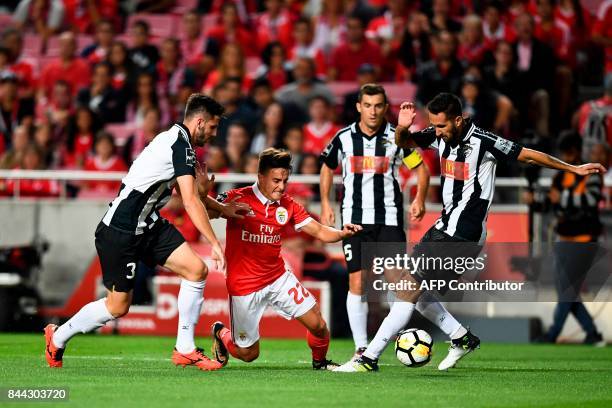 Benfica's Argentine forward Franco Servi vies with Portimonense's Brazilian Lucas Possignolo and Portimonense's defender Ruben Fernandes during the...