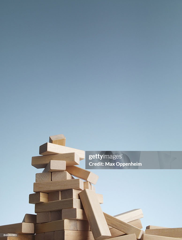 Collapsed tower of blocks against a blue sky