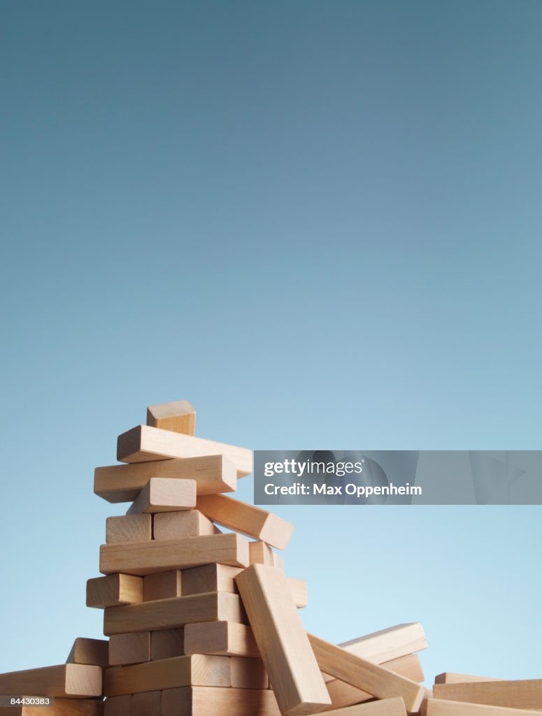 Collapsed tower of blocks against a blue sky