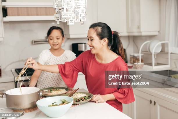 mutter und tochter im hause  - filipino family dinner stock-fotos und bilder