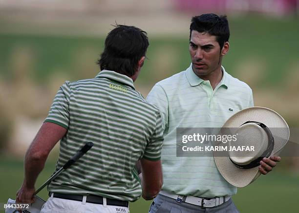 Spain's Alvaro Quiros talks to Australia's Brett Rumford before the start of the third round of the Qatar Masters tournament at the Doha Golf Club on...