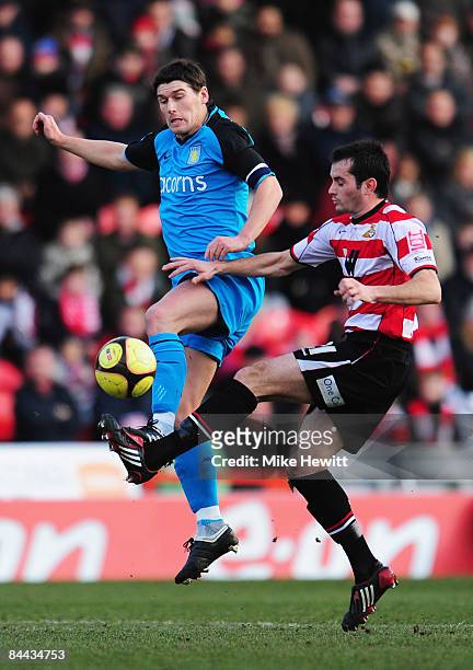 Sam Hirdof Doncaster Rovers jumps with Gareth Barry of Aston Villa during the FA Cup Sponsored by E.on 4th Round match between Doncaster Rovers and...
