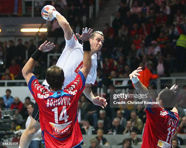 Pascal Hens of Germany scores a goal against Mladen Bojinovic of Serbia and Alem Toskic of Serbia during the Men's World Handball Championships main...