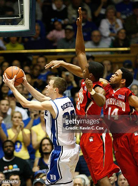 Jon Scheyer of the Duke Blue Devils drives the lane past Dino Gregory and Sean Mosley of the Maryland Terrapins on January 24, 2009 at Cameron Indoor...