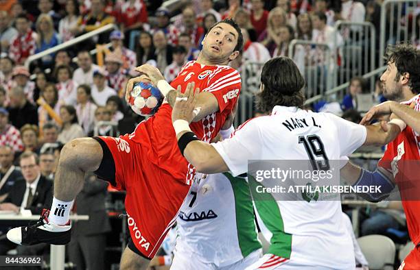 Croatian Blazenko Lackovic jummps to shoot against Hungarian Laszlo Nagy during their main round match of 'Group I' for the men�s World Handball...