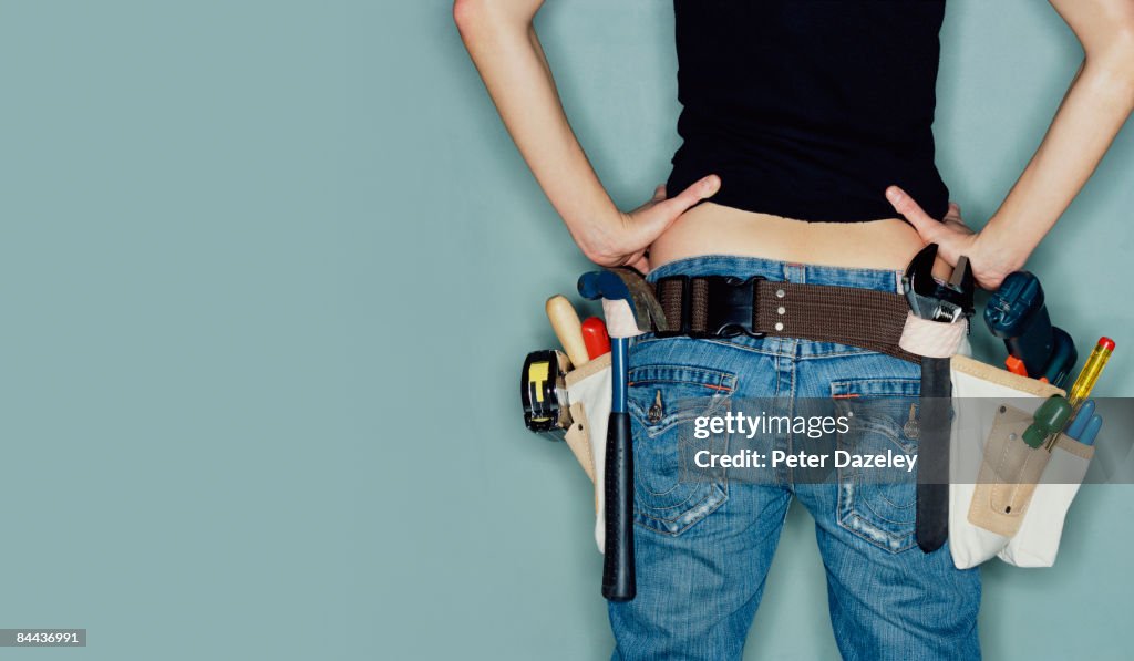 Young woman wearing tool belt