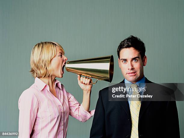 woman shouting at men with phone - aggression studio stock-fotos und bilder