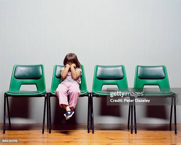 child with hands covering eyes sitting on chair - abandoned hospital stock pictures, royalty-free photos & images