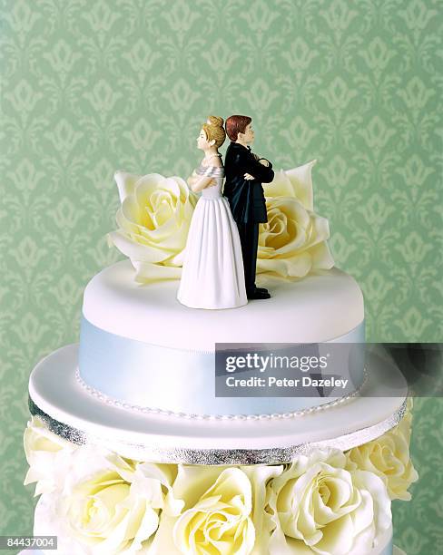 wedding cake with couple having argument - divorce stockfoto's en -beelden