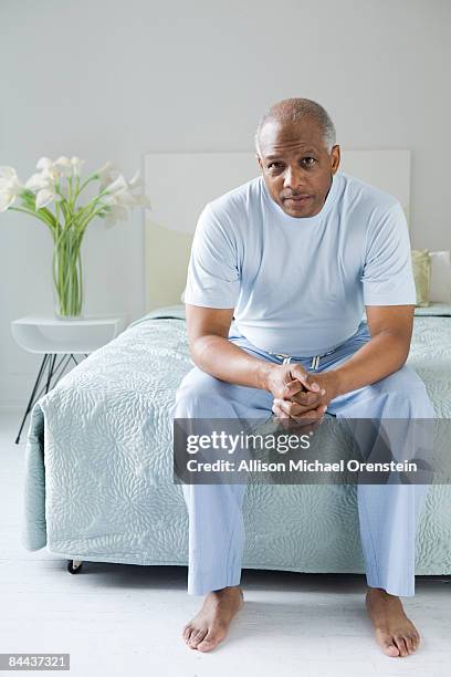 man sitting on edge of bed - michael sit stock pictures, royalty-free photos & images