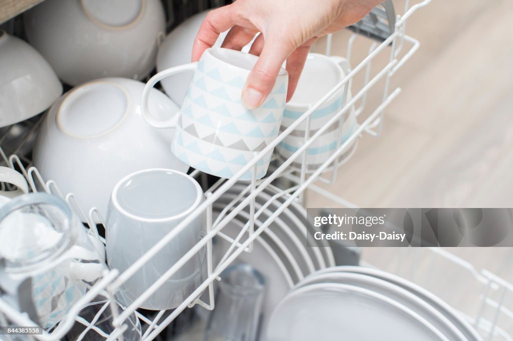 載入到洗碗機的陶器的女人的特寫