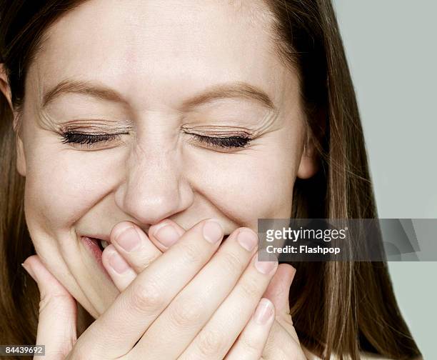 portrait of woman laughing - touching face stock pictures, royalty-free photos & images