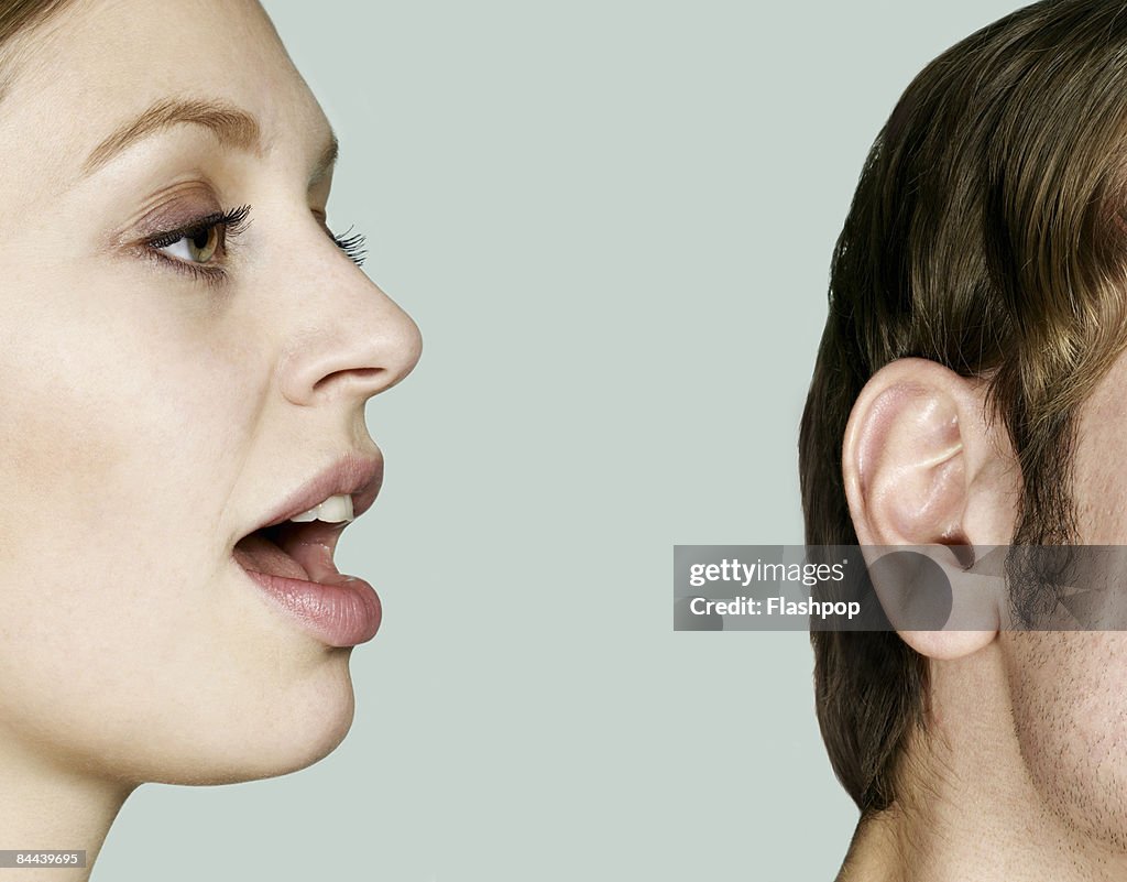 Woman talking into man's ear