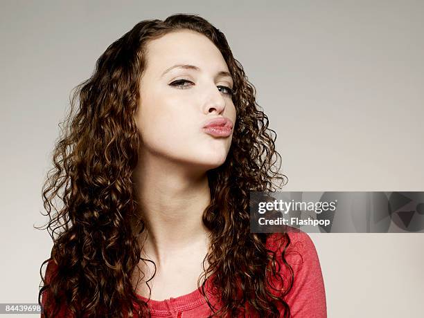 portrait of woman blowing a kiss - female puckered lips stockfoto's en -beelden