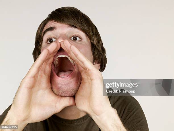 portrait of man shouting - shout photos et images de collection