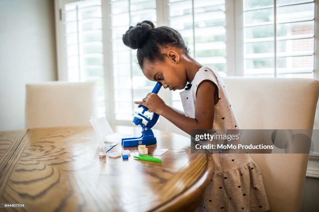 Young girl looking in microscope