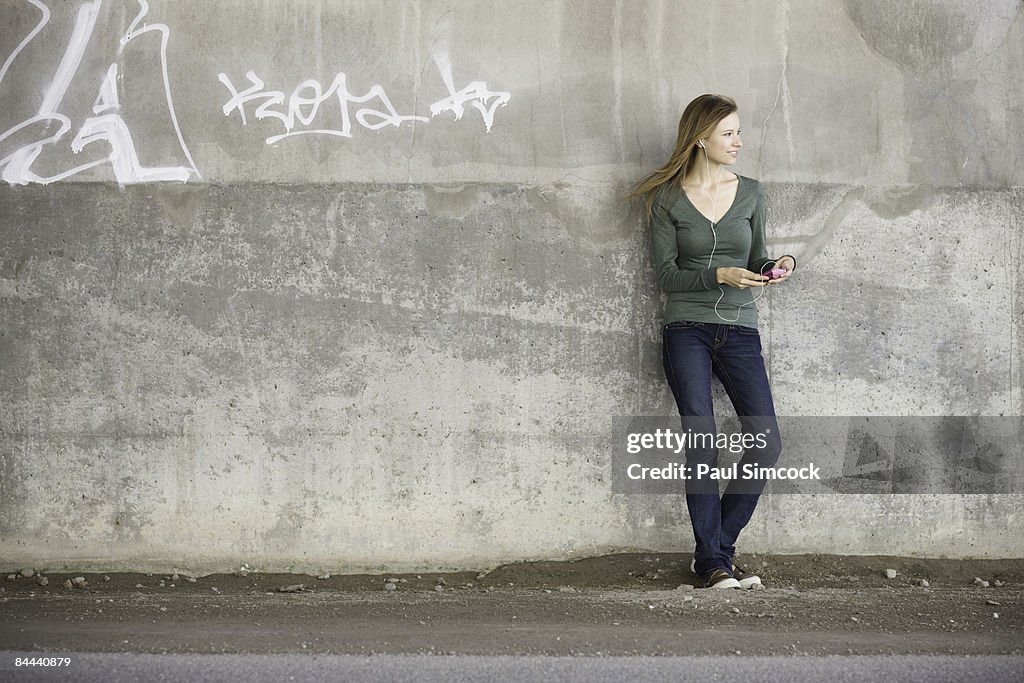Young woman listening to music in urban setting