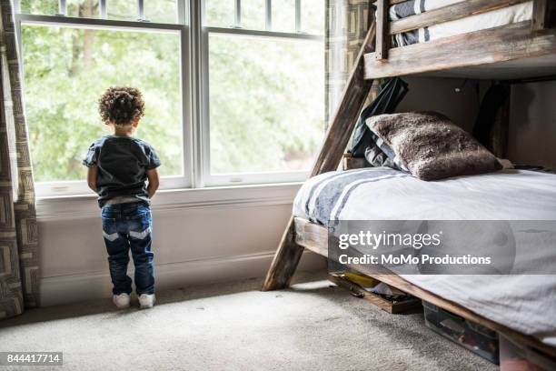 young boy (2yrs) looking out window - bunk beds for 3 stock pictures, royalty-free photos & images