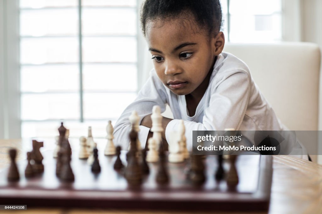 Young girl (6yrs) playing chess with