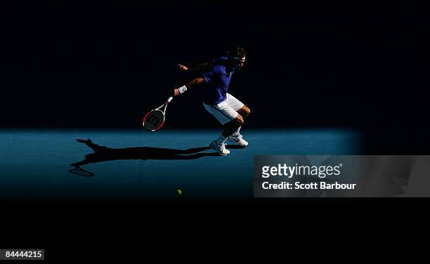 Roger Federer of Switzerland plays a backhand in his fourth round match against Tomas Berdych of the Czech Republic during day seven of the 2009...