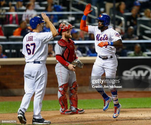 Jose Reyes of the New York Mets celebrates his fifth inning two run home run with teammate Seth Lugo as Tucker Barnhart of the Cincinnati Reds looks...