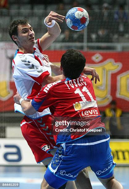 Alem Toskic of Serbia tackles Krzystof Lijewski of Poland during the Men's World Handball Championships main round match group two between Serbia and...