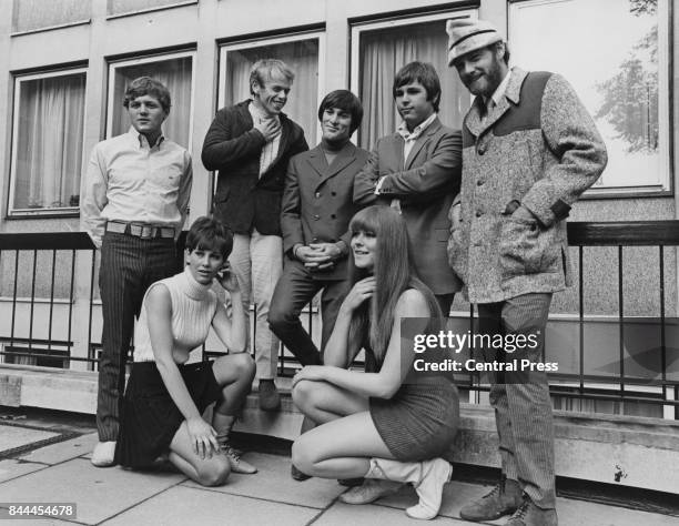 American rock band The Beach Boys pose outside EMI House in Manchester Square, with two young women, whilst in London for a concert tour, 7th...