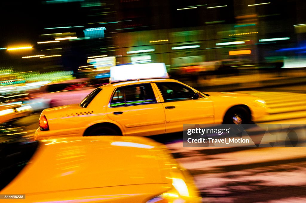 Yellow cab with panning motion at night in Manhattan