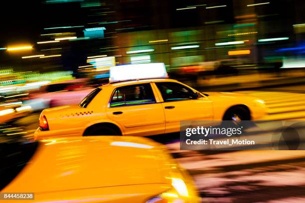 yellow cab with panning motion at night in manhattan - yellow cab stock pictures, royalty-free photos & images