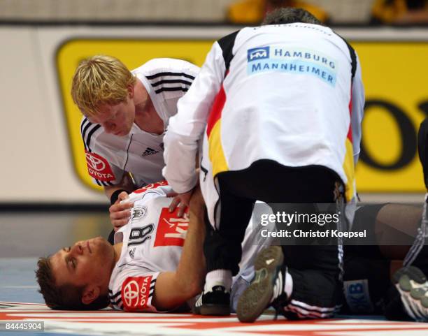 Michael Kraus of Germany lies on the pitch after an injury during the Men's World Handball Championships main round match group two between Norway...