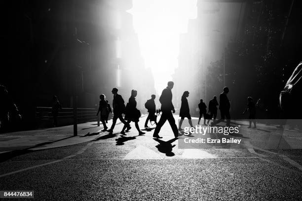 business people walking through the city - blanco y negro fotografías e imágenes de stock