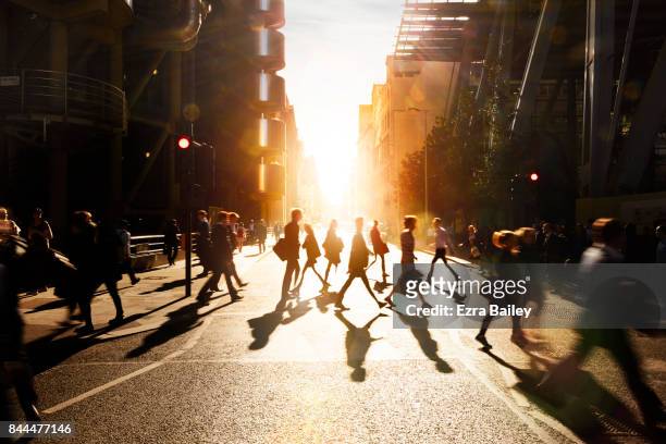 business people walking through at city at dawn. - in movimento foto e immagini stock
