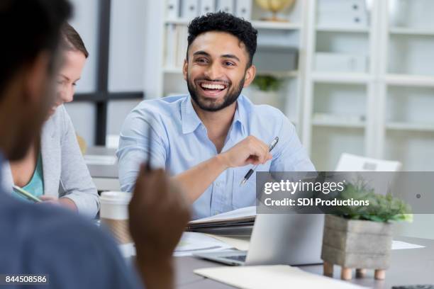 businessman laughs while meeting with colleagues - president desk stock pictures, royalty-free photos & images