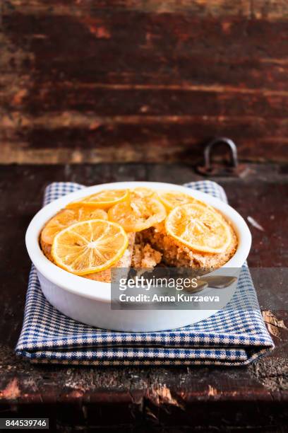 homemade lemon cake with candied lemon sliced fruit in a bowl on a wooden table, selective focus - zitronentorte stock-fotos und bilder