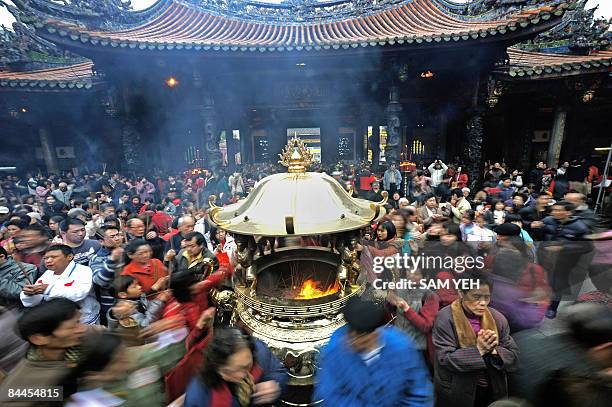 Local residents crowd into Lung Shan Temple in Taipei on January 26, 2009 to offer prays for the new Lunar New Year. Visitors prayed for good luck as...