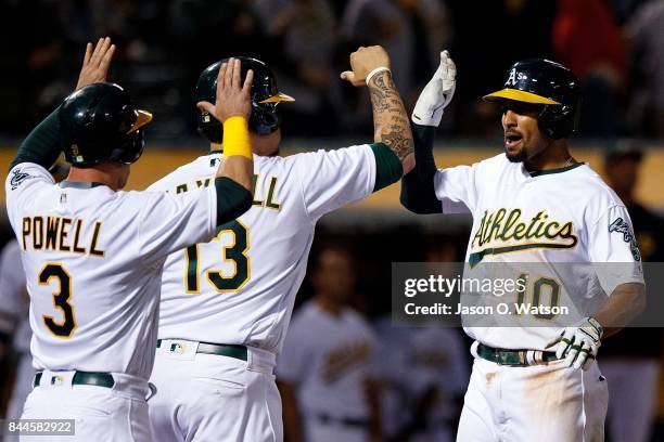 Marcus Semien of the Oakland Athletics is congratulated by Bruce Maxwell and Boog Powell after hitting a grand slam home run against the Houston...