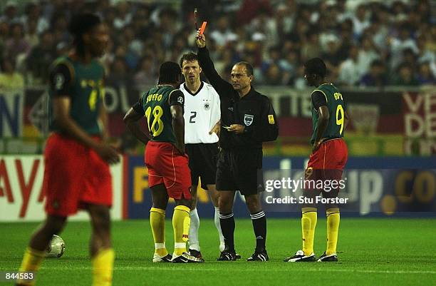 Referee Antonio Lopez Nieto shows a red card to Patrick Suffo of Cameroon during the FIFA World Cup Finals 2002 Group E match between Germany and...