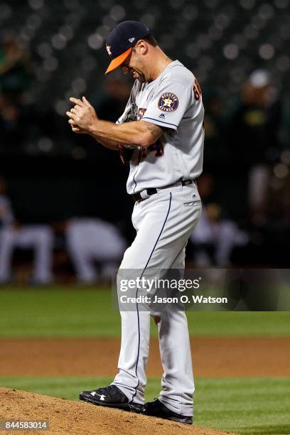 Luke Gregerson of the Houston Astros reacts after giving up a grand slam home run to Marcus Semien of the Oakland Athletics during the seventh inning...