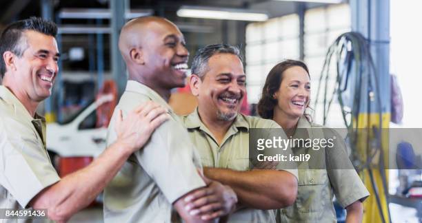 vier lkw-mitarbeiter in garage - african american mechanic stock-fotos und bilder