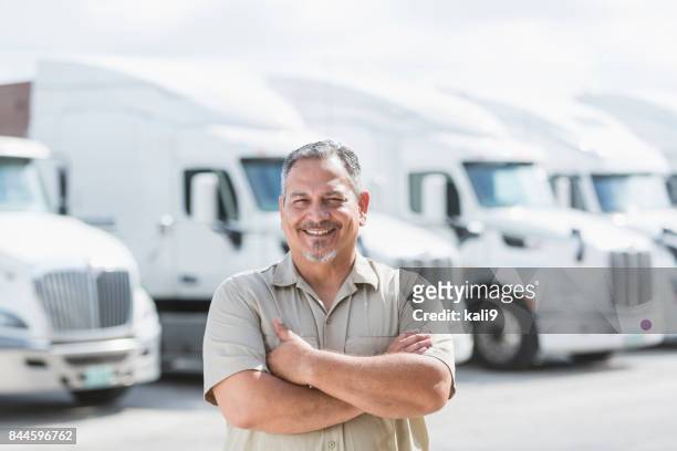hombre hispano de pie delante de semirremolques - trucker fotografías e imágenes de stock