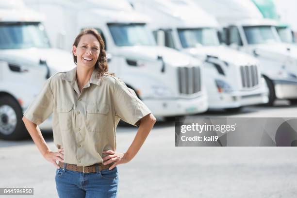 mature woman standing in front of semi-trucks - fleet manager stock pictures, royalty-free photos & images