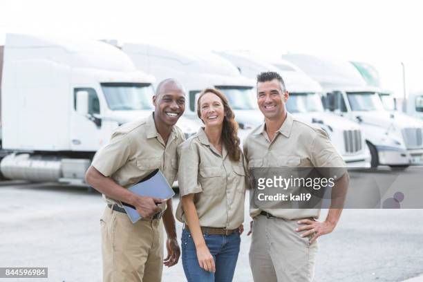 three multi-ethnic workers in front of semi-trucks - fleet manager stock pictures, royalty-free photos & images